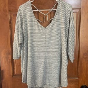 This is a gray and white stripped top with an X on the back.